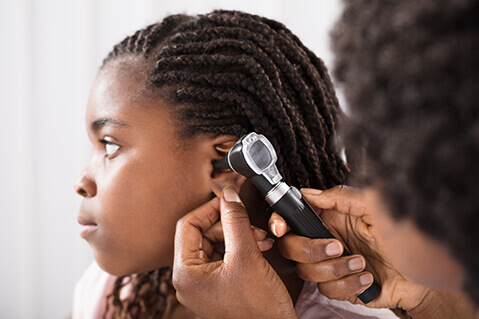 Young girl having ear exam