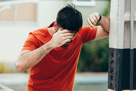 Dizzy man leaning against wall