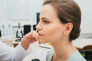 Woman having nose examined